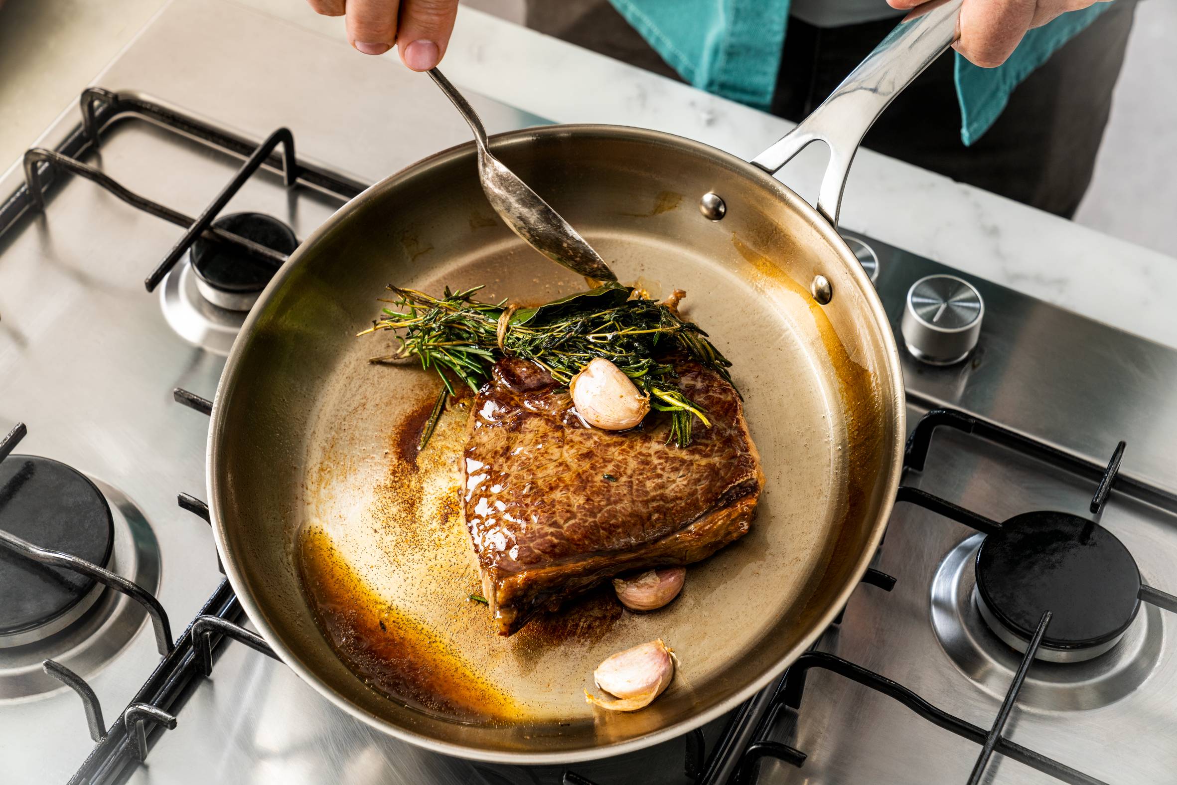 Person brät in Jamie Oliver Cook Smart Pfanne Steak an
