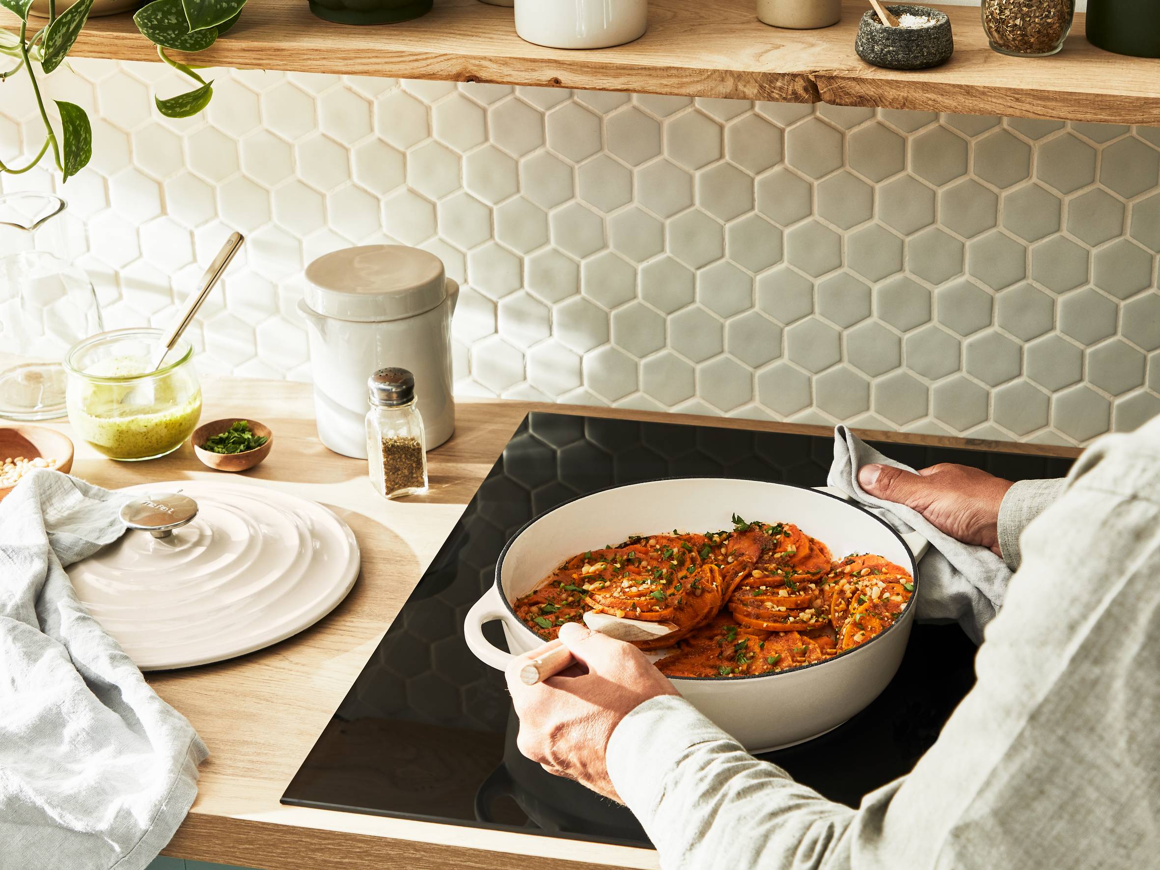 Person kocht in Tefal Gusseisentopf