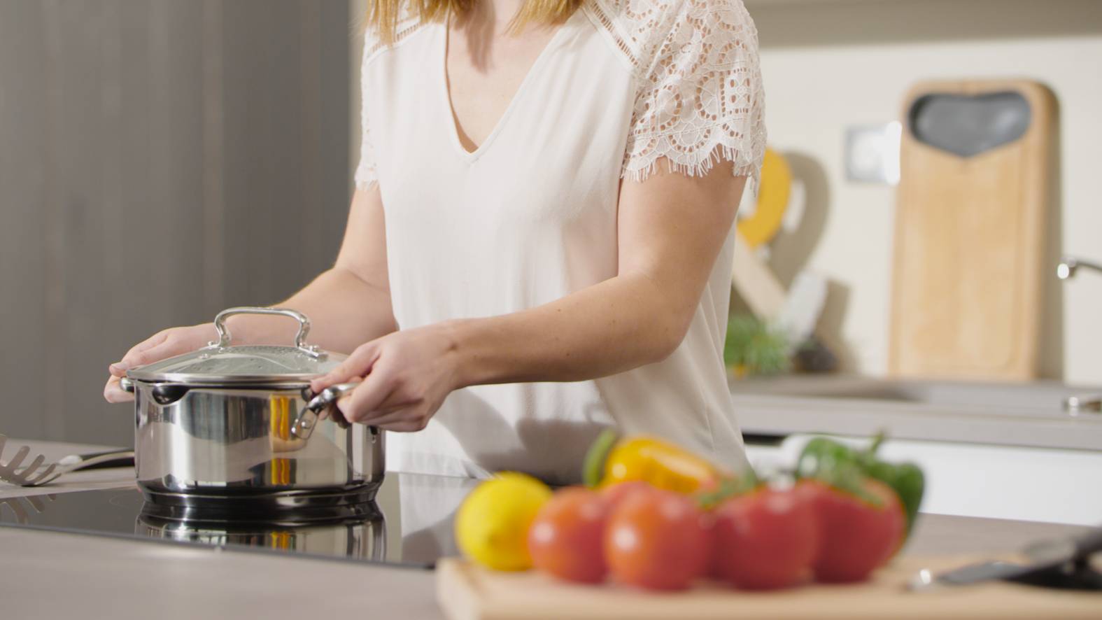 Frau stellt Tefal Induktionstopf auf den Herd